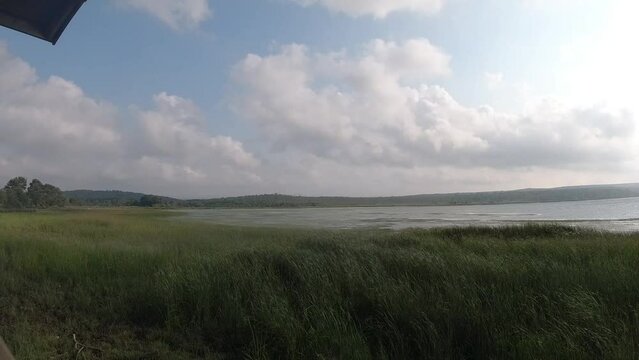 sea in cloudy weather, reeds swaying in the wind, sky and moving clouds, time-laps 2024