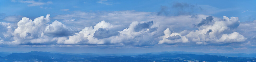 Naklejka na ściany i meble Panorama of the cloudy sky in the mountains. Cumulus clouds cover the sky, soon it will rain
