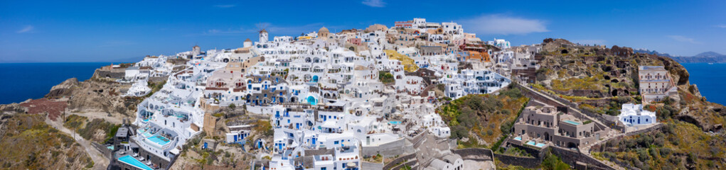 Oia town on Santorini island, Greece. Traditional and famous houses and churches with blue domes over the Caldera, Aegean sea