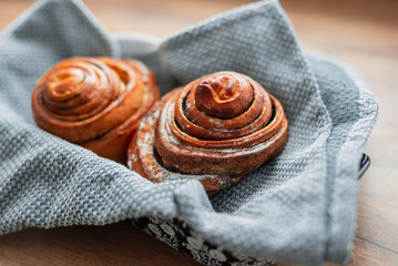 Delicious sweet pastries buns on a plate with a napkin in the kitchen on the wooden table. Flour baking