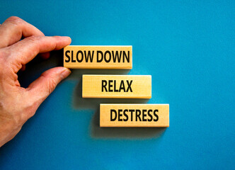 Destress symbol. Concept words Slow down Relax Destress on wooden blocks. Beautiful blue table blue background. Doctor hand. Psychological business slow down Relax destress concept. Copy space.