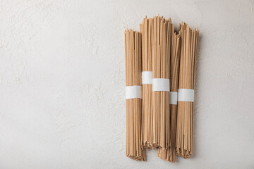 Buckwheat paste on a background of gray cement. Raw noodles. Ingredients for a gluten free dish. Dried buckwheat soba noodles. Traditional Japanese food. Healthy food. Place to copy.