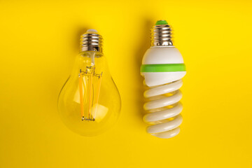 Electric light bulbs. the concept of energy efficiency. LED lamp vs incandescent lamp. Composition on a yellow background. Use an economical and environmentally friendly light bulb concept.