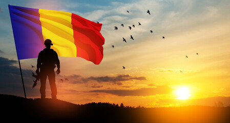 Silhouette of soldier with national flag on background of sunset. Romania National Day, the Great...