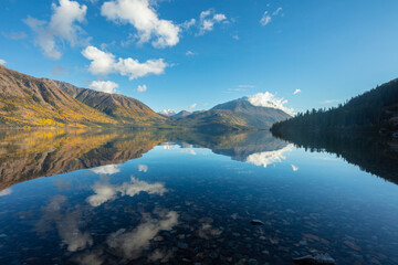Fototapeta na wymiar Perfect reflection; mountains in autumn colors reflect in a lake, Yukon territory, Alaska