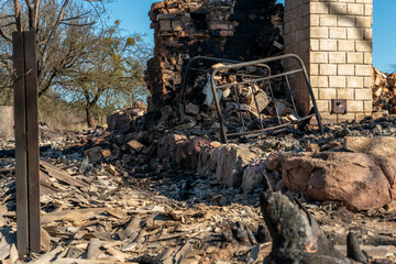 Destroyed houses as a result of a fire in Russia. Bricks and parts of walls, various household items, broken windows covered with ash lie on the surface of the earth. Natural disaster