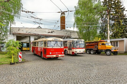 Marienbad, Czech Republic - May 21 2022: Two Skoda trolleybuses, 9Tr and 14Tr standing in front of a garage on grey cobblestone paving. Anniversary of 120 years of public transportation in the city.