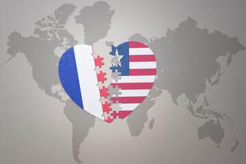puzzle heart with the national flag of france and liberia on a world map background. Concept.