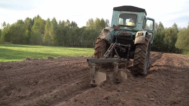 selective focus. a peasant plows the land on a tractor