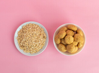 Flatlay atmeal, oatmeal cookies on a white plate on a pink background, top view, the concept of healthy eating and making cereal or cookies. High-quality photo