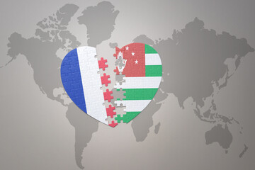 Fototapeta premium puzzle heart with the national flag of france and abkhazia on a world map background. Concept.