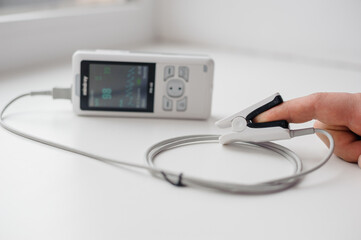 Man using finger pulse oximeter, healthcare monitoring concept. Pulse oximeter on a white background