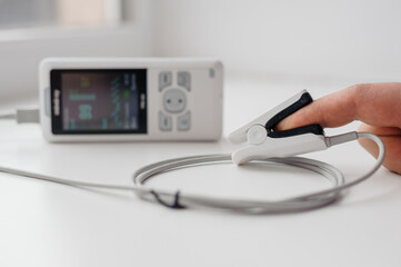 Man using finger pulse oximeter, healthcare monitoring concept. Pulse oximeter on a white background