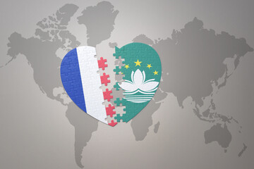 puzzle heart with the national flag of france and Macau on a world map background. Concept.