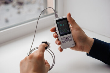 Man using finger pulse oximeter, healthcare monitoring concept. Pulse oximeter on a white background