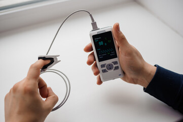 Man using finger pulse oximeter, healthcare monitoring concept. Pulse oximeter on a white background