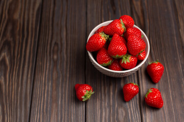 Fresh strawberries in a beautiful plate on a wooden background