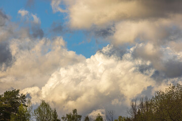 Beautiful landscape view of cumulus clouds against blue sky after rain. Sweden.