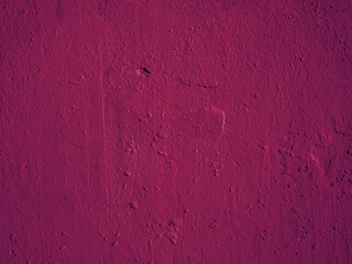 The surface of the old shabby magenta plaster on the wall.