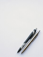 a sheet of white writing paper and two pens
