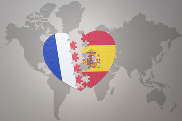 puzzle heart with the national flag of france and spain on a world map background. Concept.