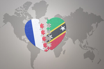 puzzle heart with the national flag of france and saint kitts and nevis on a world map background. Concept.