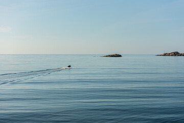 Small boat setting out to sea on a quiet and sunny morning.