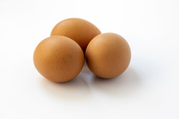 Chicken eggs on a white background, close up, three raw eggs.