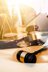 Justice and law concept.Male judge in a courtroom with the gavel, working with, computer and docking keyboard, eyeglasses, on table in morning light