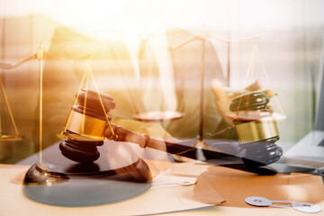 Justice and law concept.Male judge in a courtroom with the gavel, working with, computer and docking keyboard, eyeglasses, on table in morning light