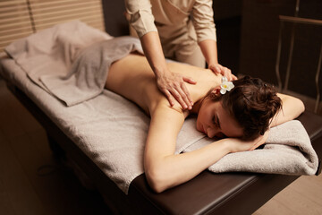 Obraz na płótnie Canvas Hands of the masseur on the female caucasian back. Horizontal view. Body healthy procedure.