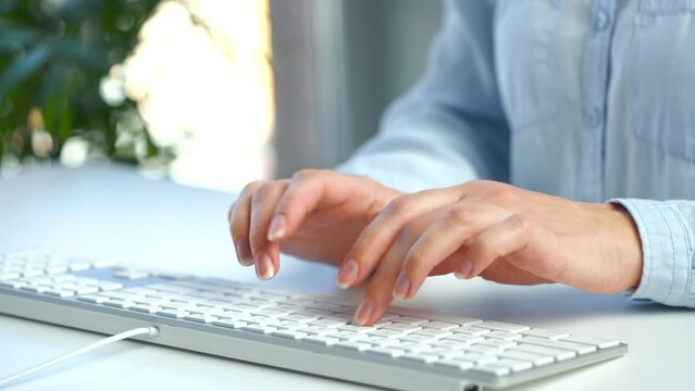 Female hands busy working on computer keyboard for sending emails and surf on a web browser