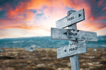feel your peace quote caption text written engraved on wooden signpost outdoors in nature with dramatic red skies.