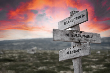 transition sustainable energy quote caption text written engraved on wooden signpost outdoors in nature with dramatic red skies.