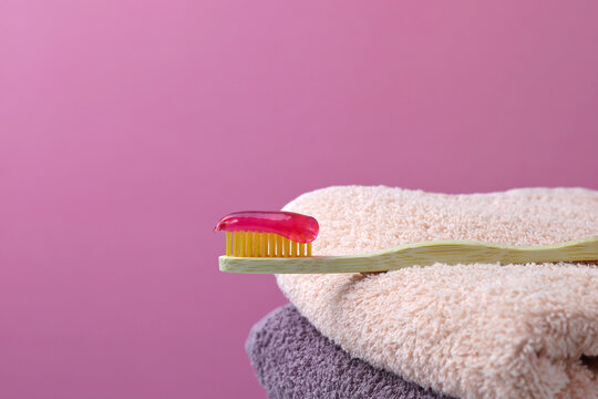 Bamboo Toothbrush, Cotton Towels. Pink Background. Biodegradable Personal Hygiene Products. There Is No Plastic Concept. Place For Text