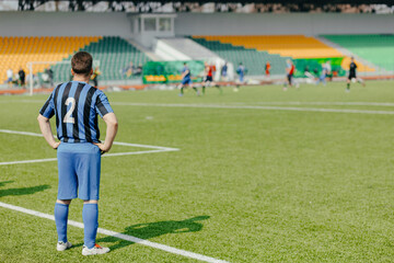 The age-old football player is in uniform number 2 near the green field line during the match