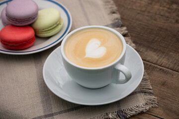 Cup of cappuccino with colorful macaroons