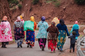 group of berber women going to work on a paved road, Ait Blal, azilal province, Atlas mountain...