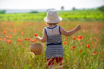 Tuinposter little girl in a field of poppies © melounix