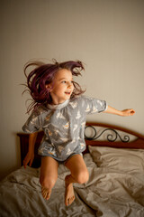the girl jumps on the bed