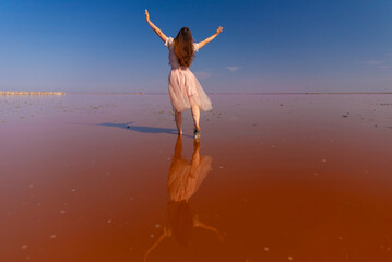 Obraz premium Woman on Pink Lake. Crimea Sasyk Sivash