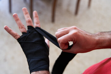 Person putting boxing wrap before training at home