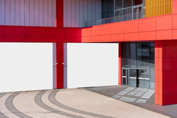 Two horizontal advert banners fixed on wall of city mall building near glass door entrance outdoor