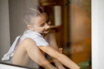 portrait of a girl sitting on the windowsill