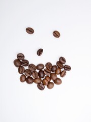 Wooden craft surface as a comfortable background wall or floor with different structures of light wood full of many aroma coffee beans. A smiling face shaped coffee beans. For best start of the day.