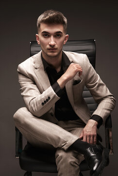 Handsome man in a classic suit in a leather chair.