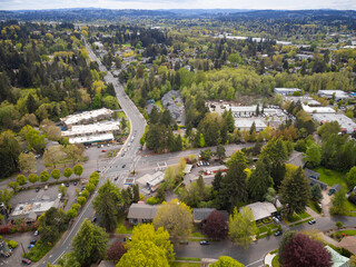 Obraz premium Drone shot. Cozy green town, suburb with developed infrastructure. A mountain range is visible in the distance. Housing issue, comfortable housing, eco-friendly place, mortgage.