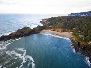 Picturesque landscape. Blue water of the ocean with white foamy waves and a small island in the middle of the ocean with coniferous trees. Beauty of nature, romance, ecology.