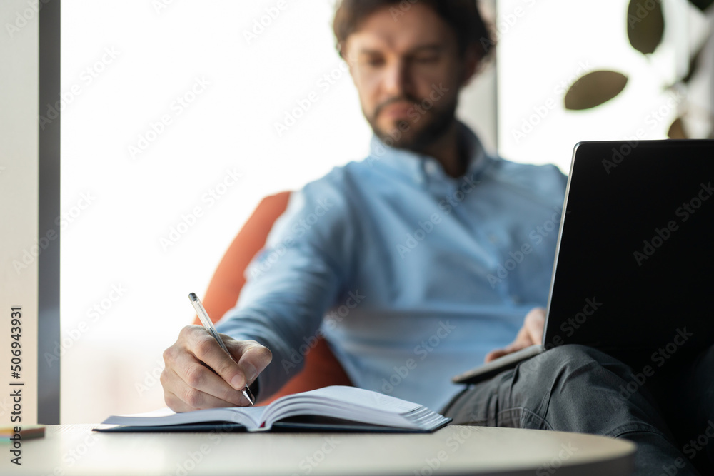 Aufkleber close up of man using laptop and writing in notebook