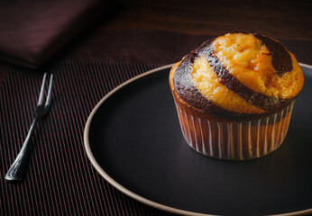 Vanilla Muffin with chocolate marbled in brown paper. close-up